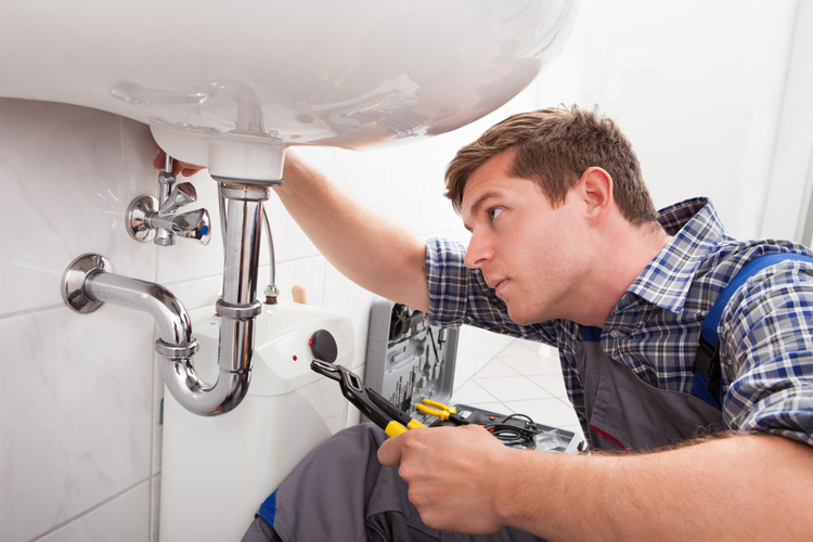 Plumber fixing a sink drain